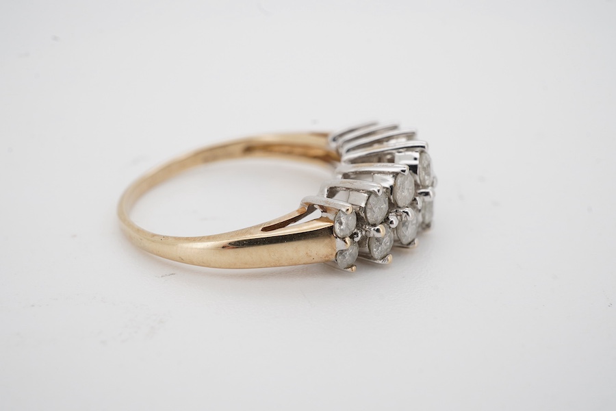 A modern 9ct gold and diamond half hoop ring, set with two graduated rows of seven diamonds, size M/N, gross weight 3.1 grams. Condition - fair to good